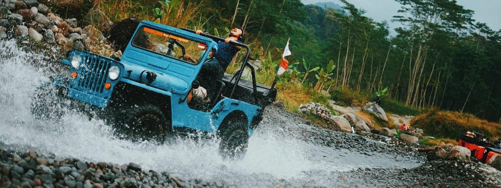 woman in black jeep wrangler on river during daytime