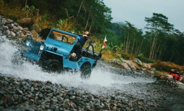 woman in black jeep wrangler on river during daytime