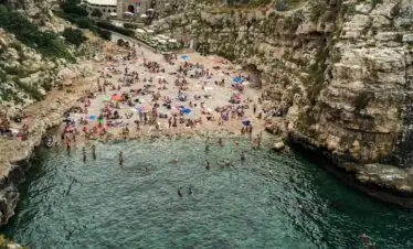 people in seashore near rocks