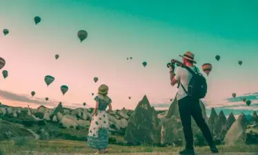 man taking photo of hot air balloons