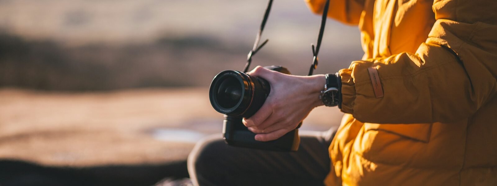 person holding Canon DSLR camera