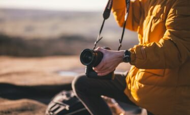 person holding Canon DSLR camera
